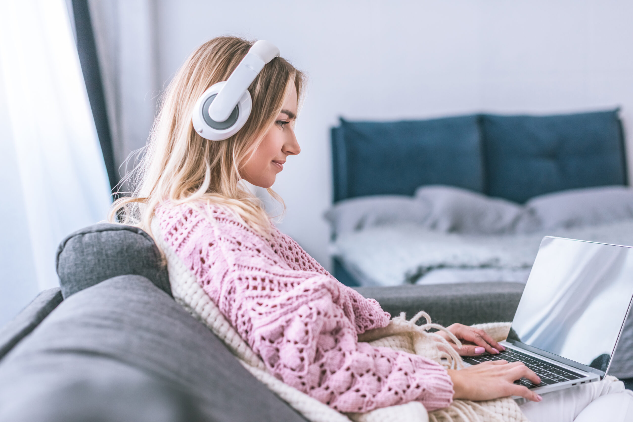 attractive woman in headphones using laptop at home