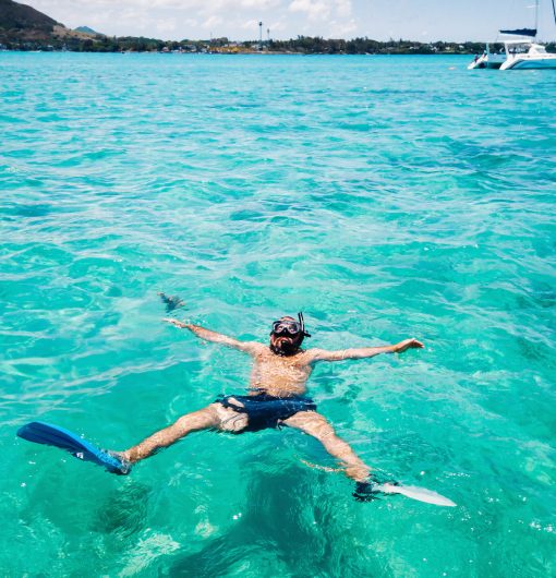 A guy in fins and a mask swims in a lagoon on the island of Mauritius.