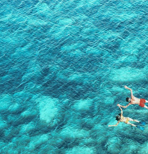 Above view of couple snorkeling in blue sea water. Summer vacation concept